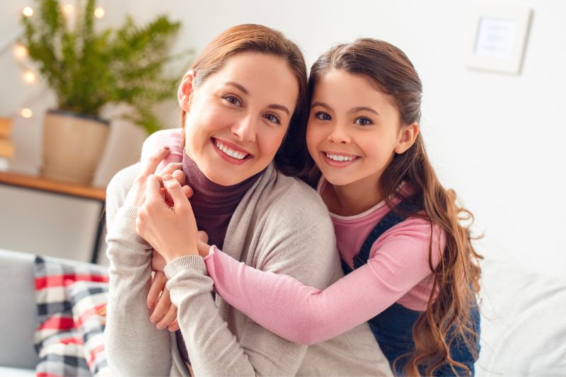 Smiling mother and daughter hugging warmly indoors Advanced Orthodontics in Kent, WA